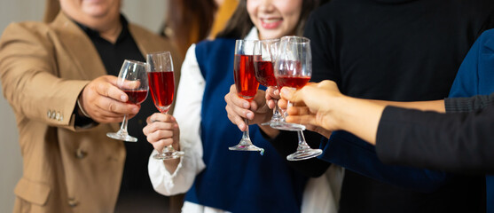Closeup hand holding glassware. Business people celebrate making a toast on event party at office. Celebration Success Concept
