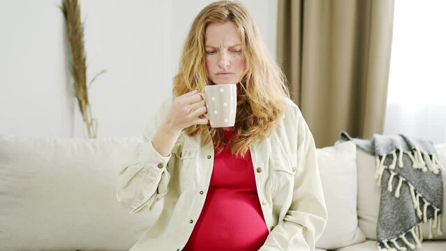 A young pregnant woman suffers from toxicosis. The expectant mother feels nauseous and develops an aversion to the smells of food and drinks. Pregnancy side effects