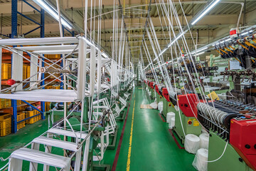 Elastic weaving workshop at textile factory in industrial zone in Ho Chi Minh City, Vietnam, with modern machinery and technology systems. - obrazy, fototapety, plakaty