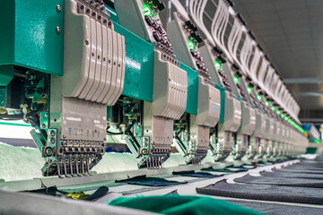 Embroidery area in textile factory in industrial zone in Ho Chi Minh City, Vietnam, with modern machinery and technology systems. - obrazy, fototapety, plakaty