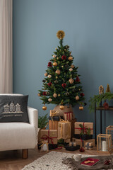 Cozy and stylish christmas living room interior with design armchair, christmas tree, gifts, wooden...