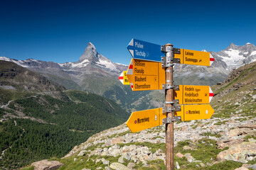 Switzerland Travel -  typical trail Signpost in the Swiss Alps in the Zermatt region with view of...