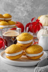 Pumpkin sandwich cookies with cream cheese on a gray concrete bsckground. Spicy autumn dessert. Copy space.