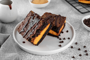 Chocolate brownies with spicy pumpkin cheesecake. Halloween or Thanksgiving dessert. Copy space.