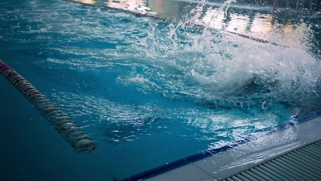 Sportsman does somersault swimming to pool edge at training