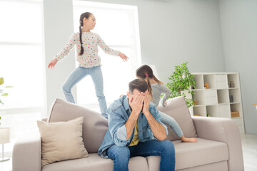 Photo of displeased exhausted guy hands cover face cheerful girls siblings playing make noise home indoors