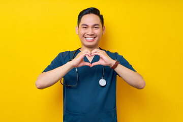 Smiling professional young Asian man doctor or nurse wearing a blue uniform and stethoscope showing...