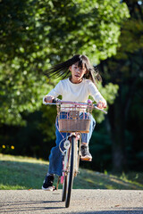 秋の公園で自転車を乗って遊んでいる小学生の女の子の様子