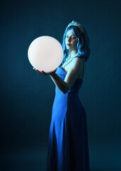 Close up portrait of beautiful female model with blue hair wearing glamorous  fantasy ball gown,...