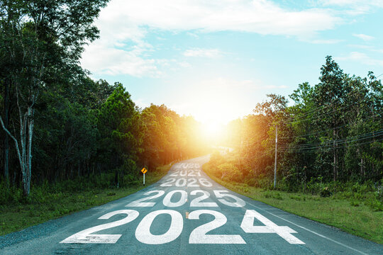 New year 2024 or 2024 planning concept of success beginning. Text 2024 written on the middle of paved road with sunset. New year plan, goals, challenges, resolutions.