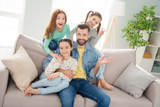 Photo of four persons handsome guy sit hug daughter girl fingers show v-sign toothy smile home indoors