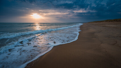 Sunset over the Atlantic, sandy beach without people.