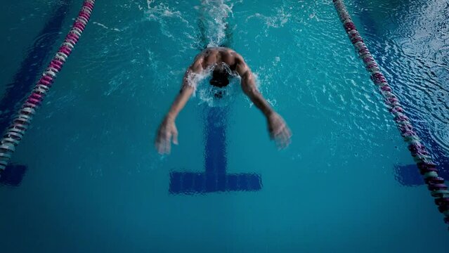 Swimmer trains butterfly style for performance in pool