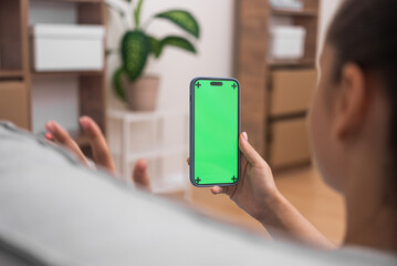 woman online call with doctor on her smartphone with chroma key screen, waving hand, consultation online at home