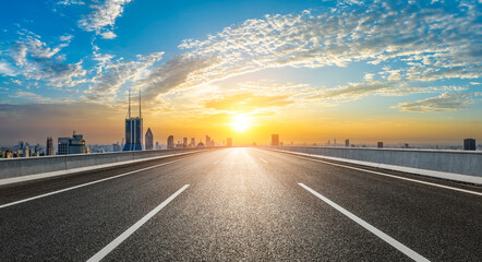 Straight asphalt highway and city skyline with modern buildings at sunset in Shanghai, China. High...
