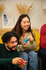 Fototapeta premium Multiracial friends playing video games in shared student apartment.
