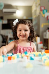 portrait of latin american little child playing with colored block