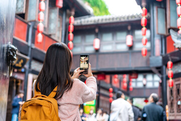 Young female tourist taking a photo of the Jinli Ancient Street in Chengdu, China