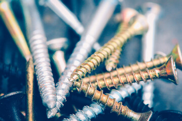 Different Kind of Screws on a table in a workshop - obrazy, fototapety, plakaty