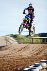 Person, motorcycle or bike jump on race track as professional in action competition, fearless or...
