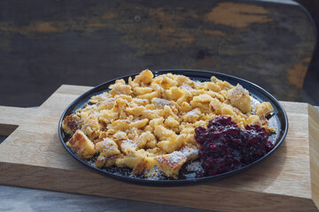 eating on the balcony at a autmn day - semolina omelet dessert with homemade cranberry jam served on a black plate