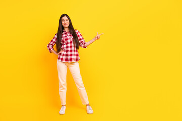 Full body photo of charming yung lady direct finger empty space cute smile look camera isolated yellow color background