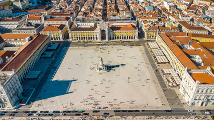 Fototapeta premium Aerial drone point of view of Commercio Square, Downtown Lisbon, Portugal. Panoramic view of cold city center. Travel destination visited annually by many foreigner tourists. Sunset colours 