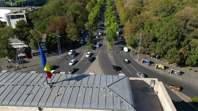 Aerial drone footage of the Free Press Square viewed from the Arcul De Triumf square in the capital of Romania - Bucharest. Kiseleff road seen from the air. Aerial video. Flag of Romania
