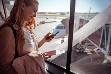 Traveler checking her phone while waiting at the airport
