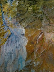Vertical shot of a rugged sandstone mountain surface, featuring rocky outcroppings