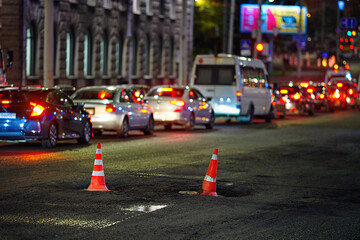 Traffic cone stands on sewer manhole, prevent car damage, collision with hatch. Road repair,...