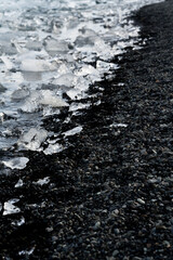 Small pieces of ice on the black sand Diamond beach in Iceland