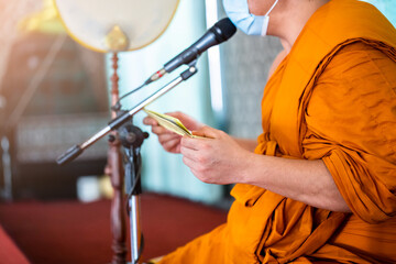 A monk is reading scriptures to teach Buddhists. Buddhist training ceremony. - obrazy, fototapety, plakaty