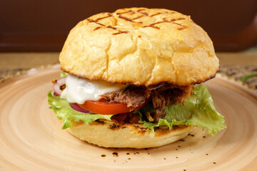 Juicy burger with chopped beef, cheese salad and tomato close-up. Selective focus