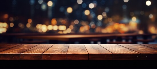 The empty wooden table top with blur background of restaurant at night.