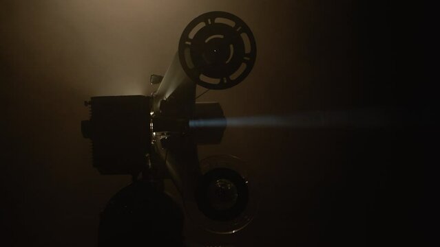 antico proiettore vintage in pellicola super 8mm con fascio di luce immerso nella nebbia