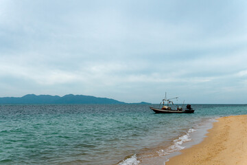 Obraz premium Fishing boat near the shore with blue sky as the background