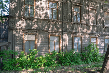 An old wooden house built in the 19th century. Architecture of the last century. Residential dilapidated house built in the last century. Old house with carved wooden elements
