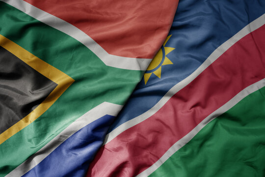 big waving national colorful flag of south africa and national flag of namibia .
