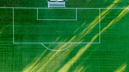 Aerial closeup of the penalty area on an empty synthetic grass soccer field.