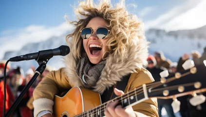 Foto auf Acrylglas Cradle Mountain Young woman playing guitar and singing on the stage in the snowy mountains