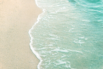 Fototapeta na wymiar Background with emerald wave on white sand.