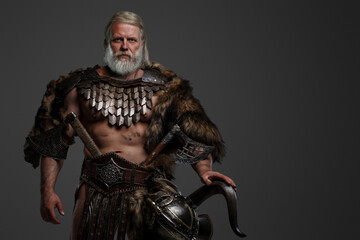 Grizzled elderly Viking warrior displaying strength and wisdom clad in furs and light armor, with a...