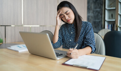 Burnout concept. Asian Business woman touching forehead having h