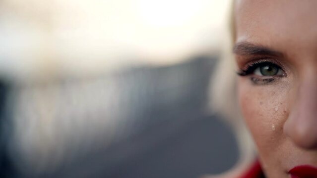 crying woman on city street, closeup view of face, lady looking at camera, tears and smeared mascara