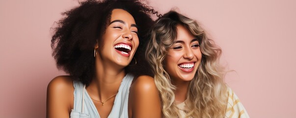 Scandinavian women smiles widely showing teeth alongside European girl friend. Cheerful best friends laugh together posing for photo. Young women of different races support each other - obrazy, fototapety, plakaty