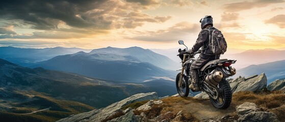 fearless biker perched at the edge of a rugged mountain cliff - obrazy, fototapety, plakaty