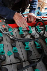 Forklift truck electric batteries being topped up at the regular maintenance check mans hand...