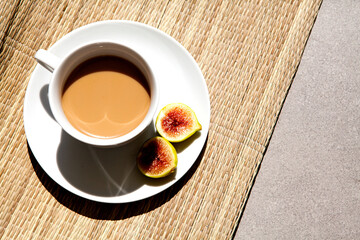 Latte in a white cup. Sweet drink with figs. coffee with milk top view on straw cover