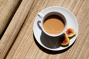 Latte in a white cup. Sweet drink with figs. coffee with milk top view on straw cover
